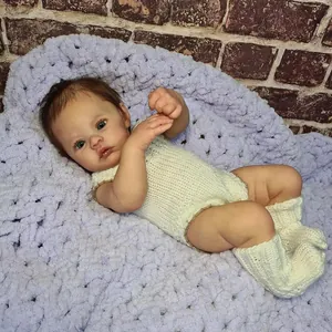 Realistic 18-inch newborn baby doll with 3D skin and knit outfit on purple blanket