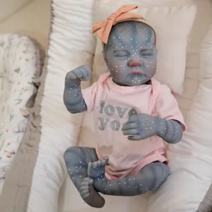 19-inch Reborn Avatar baby doll with blue skin and pink t-shirt on a striped cushion