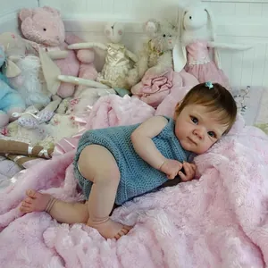 Bambola Reborn realistica Bettie da 18 pollici in tutina blu su sfondo di peluche rosa