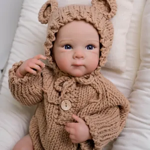 Realistic 18-inch reborn baby doll in brown knit bear outfit on quilted padding