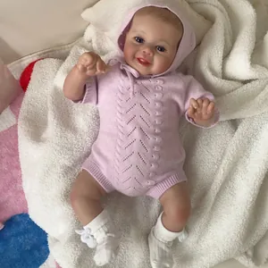 Poupée Reborn réaliste de 48 cm portant un barboteuse en tricot violet sur tapis doux