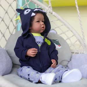 52cm Liam black reborn doll in dinosaur hoodie sitting in a cozy hanging basket chair