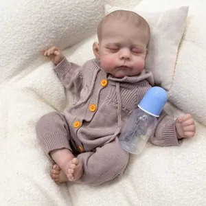 19-inch Erica reborn baby doll in brown knit romper sleeping on a soft white blanket