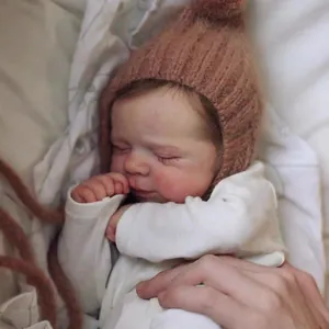 Close-up of sleeping lifelike baby doll with hand-painted details and brown knit hat