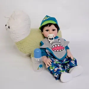 Realistic 18-inch reborn baby doll in shark-themed outfit with pacifier and bottle