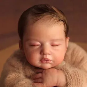 Realistic 19-inch sleeping reborn baby doll with brown hair and fuzzy knitted sweater