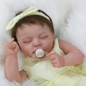 Gros plan d'une poupée reborn dormante avec bandeau jaune et sucette magnétique