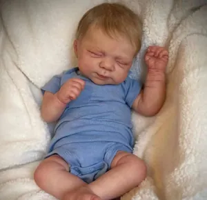 Macro shot of realistic newborn reborn doll with lifelike skin texture and blue romper