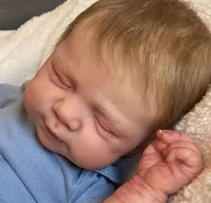 Close-up of sleeping reborn doll with detailed skin texture and rooted golden hair