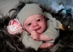 Detail of 18 inch realistic reborn doll in grey knitted outfit with floral decor