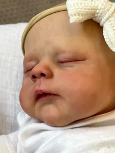 Gros plan sur la peau réaliste et le nœud en dentelle de la poupée reborn de 19 pouces
