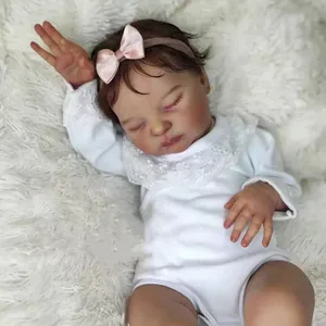 Realistic 19-inch reborn baby doll Laura in white lace bodysuit on white plush blanket
