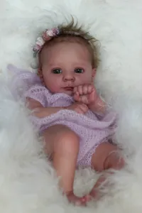 Detailed close-up of 18-inch reborn doll with realistic skin and purple lace outfit