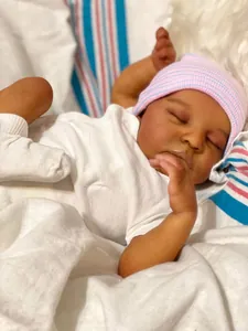 Gros plan détaillé de la poupée reborn de 18 pouces endormie avec un bonnet rose rayé