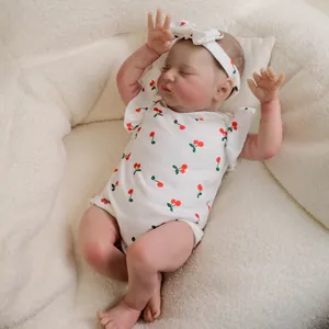 Realistic 19-inch reborn doll in cherry print outfit sleeping on soft fleece