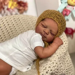 Realistische 19-Zoll Reborn-Puppe mit gelber Strickmütze schlafend in einer Wiege