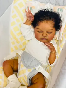 Detailed close-up of realistic 19-inch African American reborn baby doll sleeping in cradle
