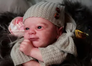 Close-up of 18-inch lifelike newborn reborn doll with realistic skin and knit hat