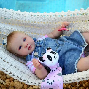 Realistische 21-Zoll-Reborn-Puppe mit Jeanslatzhose in einer weißen Strickhängematte
