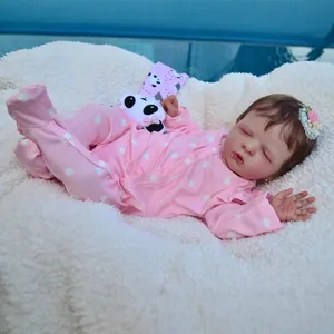 Realistic 19-inch reborn baby doll in pink heart onesie with a small panda toy