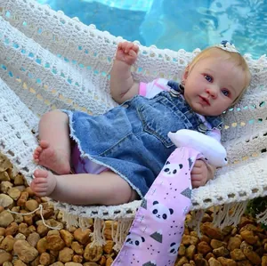 21-Zoll Reborn-Puppe im Jeanskleid in einer weißen Hängematte über Pool-Kieselsteinen