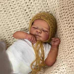 Realistische 19-Zoll Reborn-Puppe mit dunkler Haut im weißen Strampler und gelber Mütze