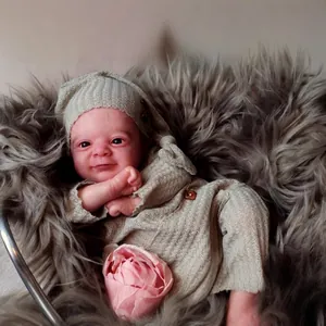 Lifelike 18-inch reborn baby doll in grey knitted outfit sleeping on plush rug