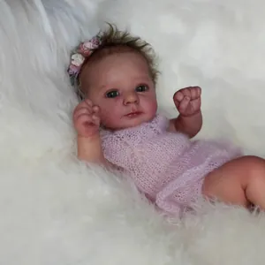 Lifelike 18-inch Felicia reborn baby doll with curly brown hair and pink crochet dress