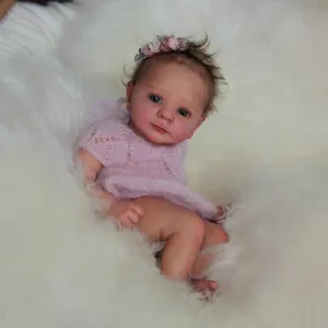 Lifelike 18-inch Felicia reborn baby doll in pink knit romper on white plush rug