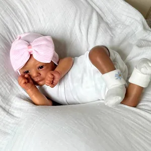 Realistic 18-inch deep skin reborn baby doll with pink bow hat and white floral socks