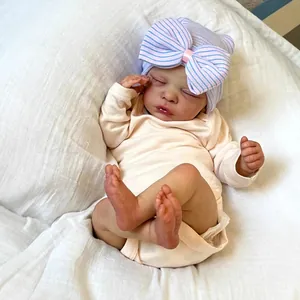 Realistic 18-inch sleeping reborn doll wearing bow hat and beige long sleeve romper