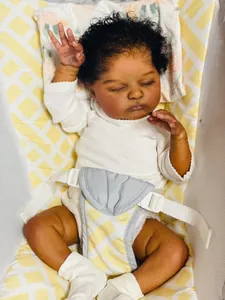 Detail of 19 inch reborn baby doll with deep skin and dark curly hair in white onesie