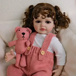 55cm lifelike reborn baby doll in pink overalls with brown curly hair and teddy bear