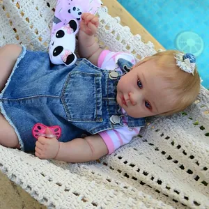 Realistische 21-Zoll Reborn-Puppe im Jeans-Latzkleid entspannt in einer weißen Hängematte