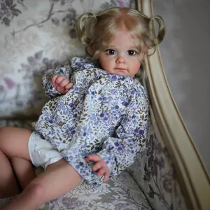 Bambola reborn realistica da 24 pollici con camicia a fiori blu sul divano