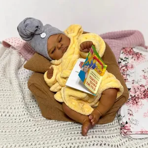 Deep skin tone sleeping reborn baby doll in yellow plush bathrobe and grey towel cap