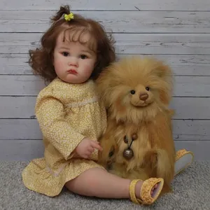Lifelike 24-inch reborn doll in a yellow floral dress with brown curly hair and bow