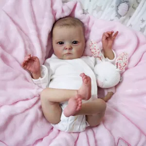 Lifelike 16-inch reborn baby doll in white romper with pink blanket and bunny toy