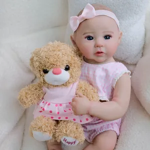 Realistic 49cm Reborn Doll Raven in pink plaid dress with a plush brown teddy bear