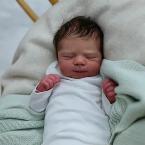 Ρεαλιστική κούκλα Reborn 19 ιντσών με λευκό φορμάκι που κοιμάται σε πράσινη πλεκτή κουβέρτα