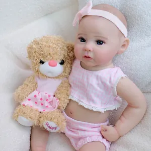 Realistic 49cm reborn baby doll Raven in pink plaid outfit with a plush teddy bear