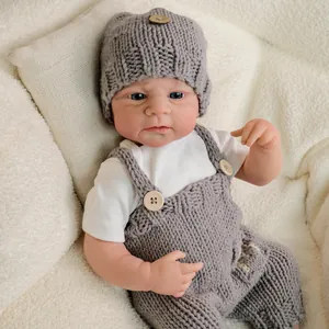 Realistic 19-inch Reborn Doll Elijah wearing gray knitted outfit on white fleece