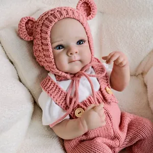 Realistic 19-inch reborn doll in pink handmade knit overalls and bear ear hat