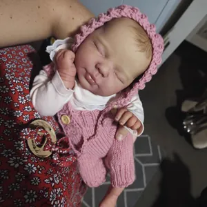 Realistic 20-inch Reborn baby doll sleeping in pink knit romper and matching warm hat