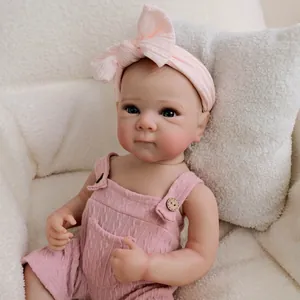 Poupée Reborn réaliste 19 pouces avec barboteuse rose et bandeau nœud sur le canapé