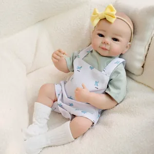 Realistic 19 inch reborn baby doll Julietta in bird print overalls and yellow headband