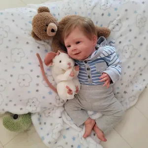 Realistic 19-inch reborn baby doll in blue striped hoodie and grey pants on soft blanket