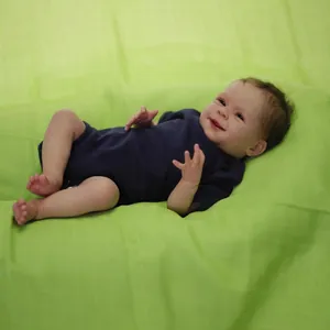 Realistische 19-Zoll Reborn-Puppe in marineblauem Strampler auf grünem Hintergrund