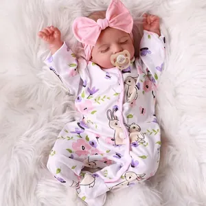 18-inch Rosalie reborn baby doll with floral bunny romper and pink bow on plush background