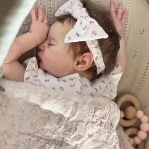 Lifelike 19-inch reborn baby doll in pink floral outfit with matching headband and soft blanket